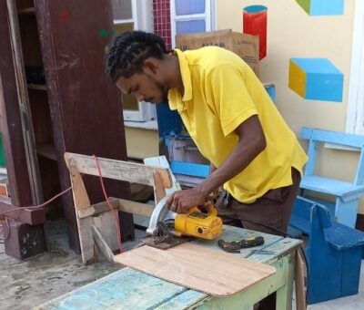 Teacher building furniture and creating prayer space for his students